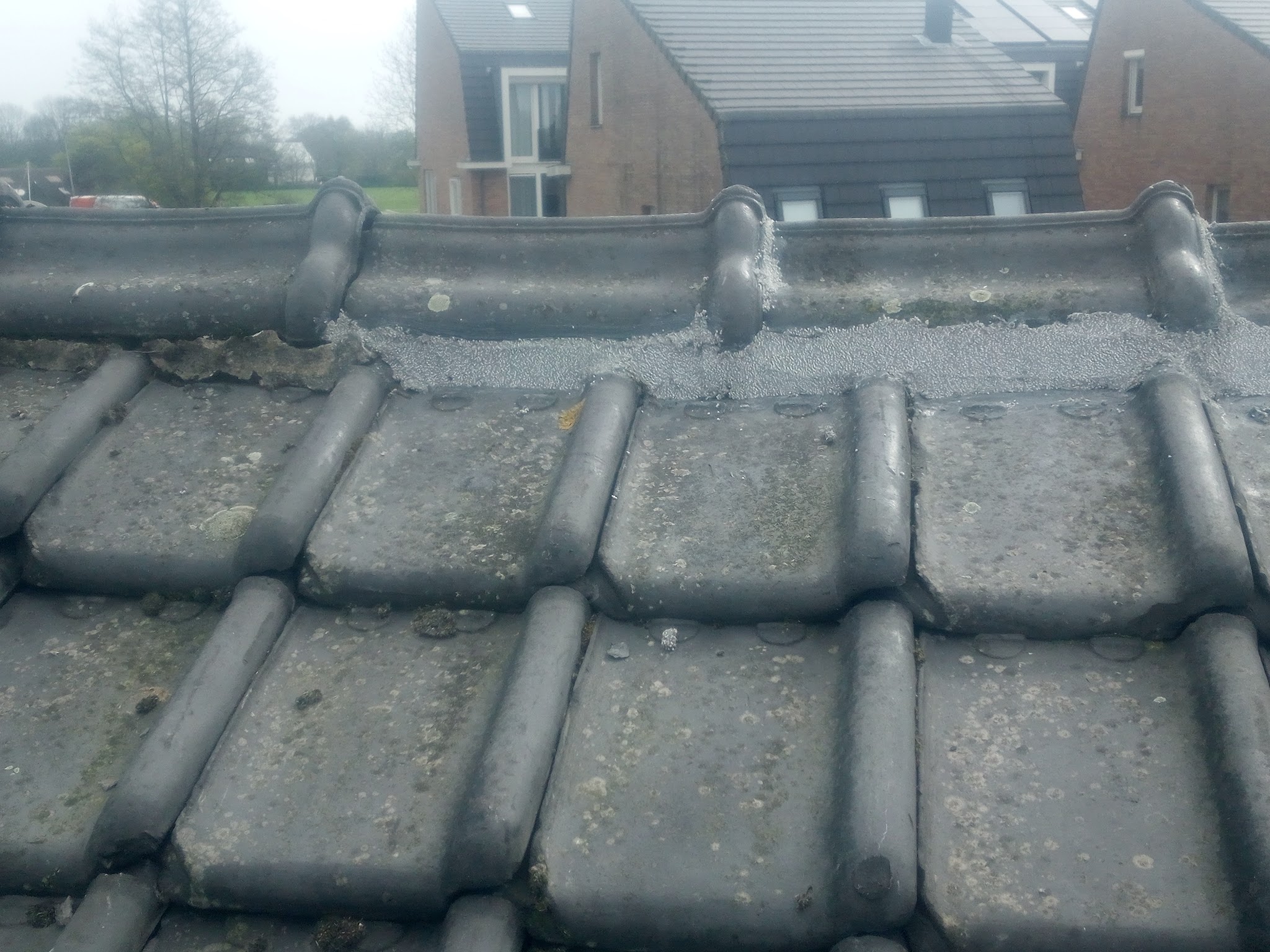Oude dakpannen op de nok van een dak, van dichtbij