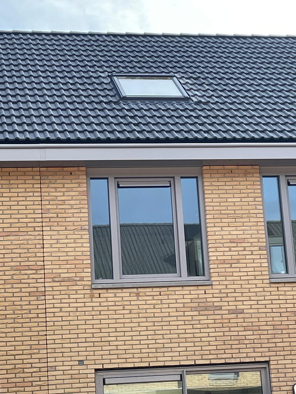 Nieuwbouwwoning met een nieuw geplaatst dakraam in het donkere pannendak